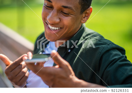 Man talking holding smartphone near face Man talking holding smartphone near face 92126331