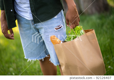 Mans hand holding bag of food Mans hand holding bag of food 92126407