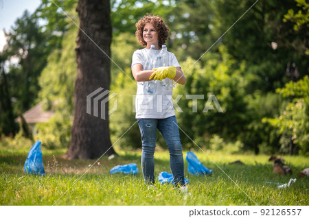 Curly-haired young volunteer gethering plastic bottles Curly-haired young volunteer gethering plastic bottles 92126557