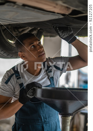 Experienced auto repair worker diagnosing car problem 92127105