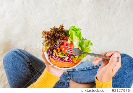 Female hands holding bowl with green lettuce salad 92127976