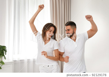 Lovely young couple dancing together at home Lovely young couple dancing together at home 92129178