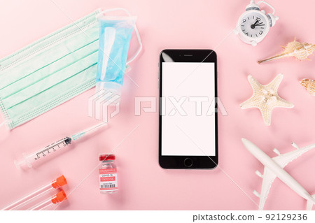 Top view model plane, medical face mask, coronavirus vaccine and smartphone 92129236
