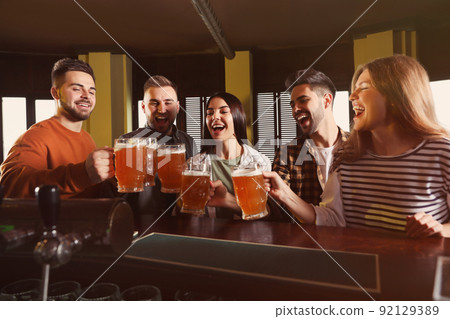 Group of friends celebrating victory of favorite football team in sport bar 92129389