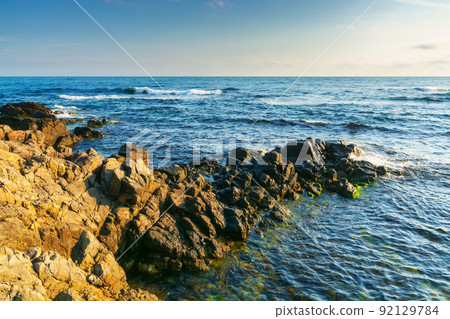 stones and rock at the sea. beautiful nature background with calm water in morning light stones and rock at the sea. beautiful nature background with calm water in morning light 92129784