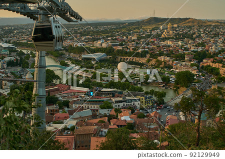 Tbilisi, Georgia sunset Panoramic view from top of fortress of Narikala showing the bridge of peace, Rike Park, the Kura River and Holy Trinity Cathedral of Tbilisi Tbilisi, Georgia sunset Panoramic view from top of fortress of Narikala showing the bridge of peace, Rike Park, the Kura River and Holy Trinity Cathedral of Tbilisi 92129949