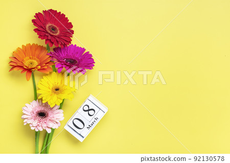 Bouquet of gerbera flowers, calendar with date 08 march on yellow background Holiday greeting card International womens day concept Flat lay Top view. 92130578