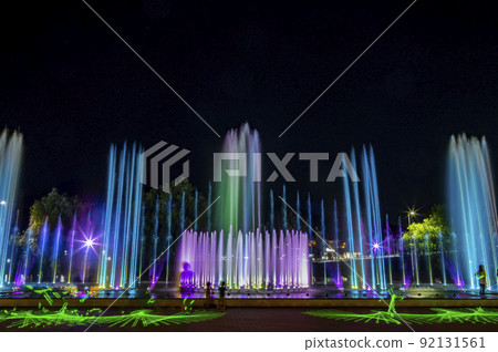 The fountain is dancing to light music and colorful lighting. Green laser light adds illumination 92131561