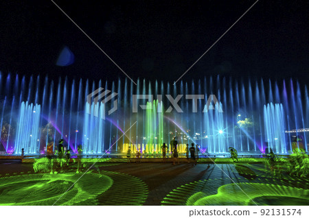 The fountain is dancing to light music and colorful lighting. Green laser light adds illumination 92131574