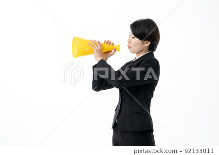 Female new employee looking into a yellow megaphone on a white background 92133011
