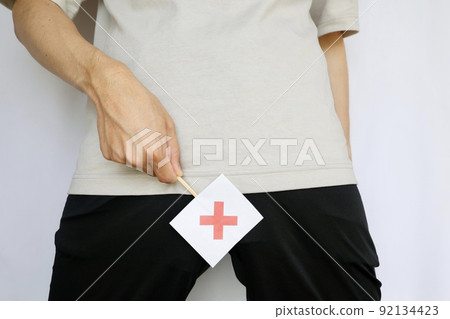 A man holding a cross in his crotch A man holding a cross in his crotch 92134423