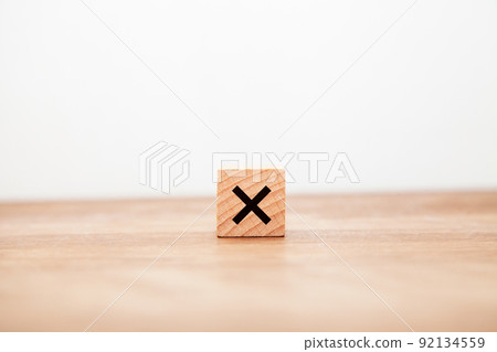 The letter x. Hang. multiplication. multiplicative. Written on a wooden block. Black letters. Wooden table background. 92134559