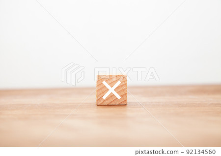 The letter x. Hang. multiplication. multiplicative. Written on a wooden block. White letters. Wooden table background. 92134560