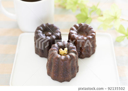 Delicious canelé and hot coffee 92135502