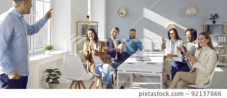 People applaud their colleague standing in front of them and have fun making business presentation. People applaud their colleague standing in front of them and have fun making business presentation. 92137866