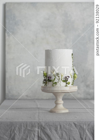 White wedding cake with lillac and green flowers 92138029