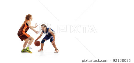 Play defense. Two basketball players, young girls, teen training with basketball ball isolated on white background. Concept of sport, team, enegry, competition, skills 92138055