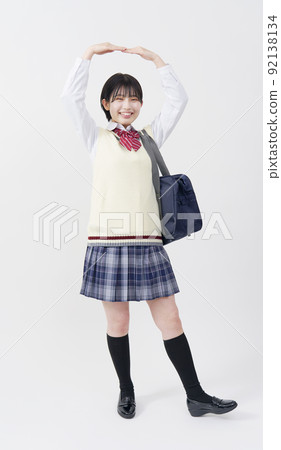 用手臂做圓圈手勢的高中女生，全身白色背景 92138134