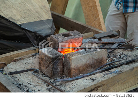 hammer in the blacksmith's forge close-up, heating up the metal hammer in the blacksmith's forge close-up, heating up the metal 92138625