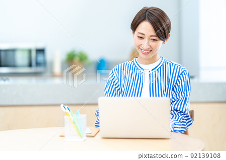 Middle woman teleworking in the living room 92139108