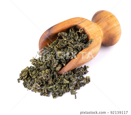Dry gynostemma pentaphyllum leaf in wooden scoop, isolated on white blackground. Jiaogulan or Miracle grass. Chinese herbal tea. Dry gynostemma pentaphyllum leaf in wooden scoop, isolated on white blackground. Jiaogulan or Miracle grass. Chinese herbal tea. 92139117