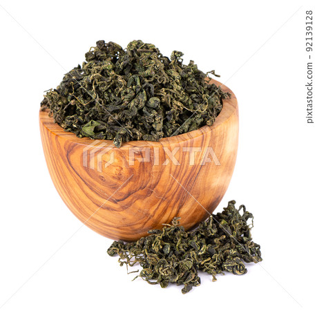Dry gynostemma pentaphyllum leaf in olive bowl, isolated on white blackground. Jiaogulan or Miracle grass. Chinese herbal tea. 92139128