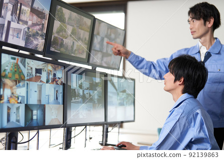 Security guard checking the video of the surveillance camera Security guard checking the video of the surveillance camera 92139863