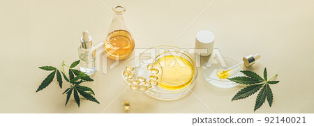 CBD oil in laboratory glassware, Petri dishes. Capsules, THC tincture, CBD oil and hemp leaves, light background CBD oil in laboratory glassware, Petri dishes. Capsules, THC tincture, CBD oil and hemp leaves, light background 92140021