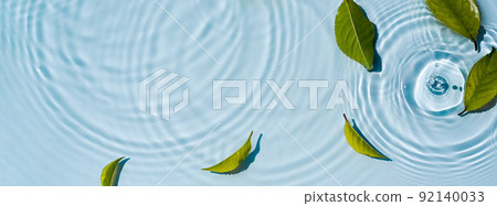 Transparent and clean blue water and green background of natural leaves 92140033