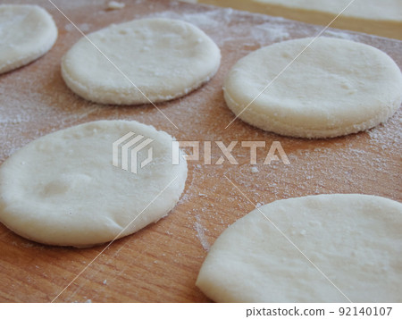 Cooking yeast dough. Working with dough in the kitchen. Close-up on rolled out dough. Cooking yeast dough. Working with dough in the kitchen. Close-up on rolled out dough. 92140107