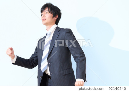 A business person in a suit who makes a small guts pose with one hand A business person in a suit who makes a small guts pose with one hand 92140240