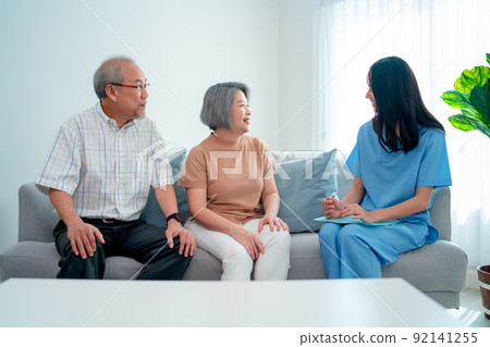 Asian nurse or doctor discuss with senior man and woman in living room with concept of home care 92141255