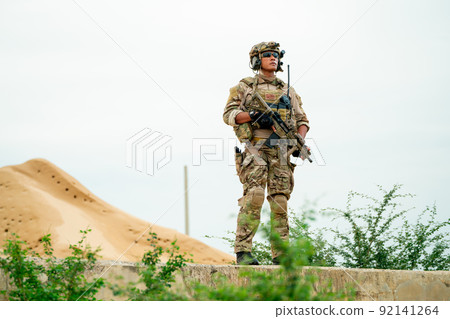 Soldier or military man stand with guarded position and look around in area look like desert 92141264