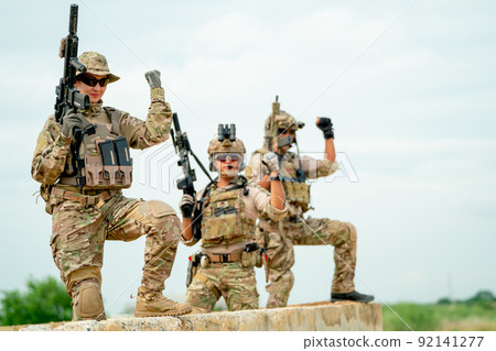 Military or soldier team with gun stay on concrete wall and also raise one's hand for action Military or soldier team with gun stay on concrete wall and also raise one's hand for action 92141277