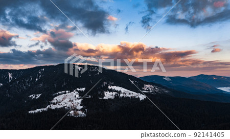 Panorama of the Carpathians in the Synevyrska Polyana Natural Park, forest with snow and morning fog and clouds, clouds at the foot of the mountains. 92141405