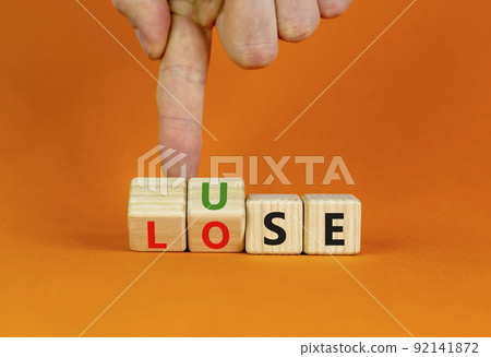 Use or lose symbol. Concept words Use or lose on wooden cubes. Businessman hand. Beautiful orange table orange background. Business Use or lose concept. Copy space. 92141872