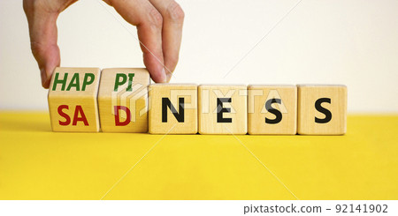 Happiness or sadness symbol. Businessman turns cubes and changes the word 'sadness' to 'happiness'. Beautiful white background. Business, psychological and happines or sadness concept. Copy space. Happiness or sadness symbol. Businessman turns cubes and changes the word 'sadness' to 'happiness'. Beautiful white background. Business, psychological and happines or sadness concept. Copy space. 92141902