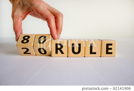80 on 20 rule symbol. Pareto principle. Male hand flips wooden cubes with words '80 on 20 rule'. Beautiful white background, copy space. Business and 80 on 20 rule, pareto principle concept. 92141906