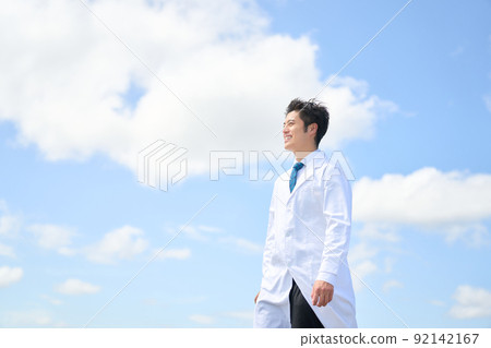 一個穿著白大褂的男人微笑著走到戶外 92142167