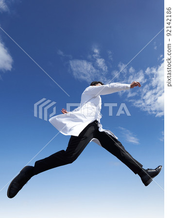 一個穿著白大褂的男人在藍天下跳躍 一個穿著白大褂的男人在藍天下跳躍 92142186