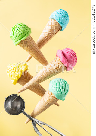 Flying colorful ice cream scoops in cones, bright background. Levitation 92142275