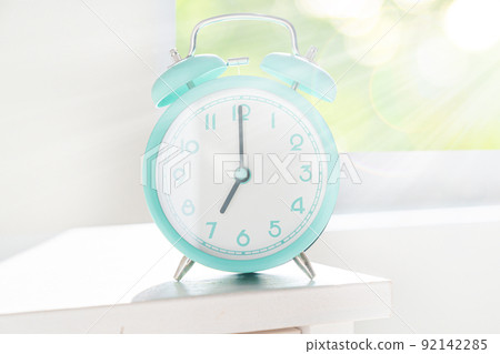 Circadian rhythms concept - alarm clock set on 7 am with sun rays Circadian rhythms concept - alarm clock set on 7 am with sun rays 92142285
