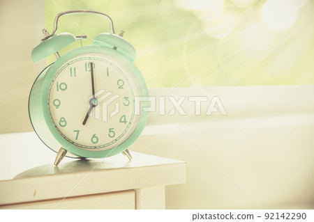 Circadian rhythms concept - alarm clock set on 7 am with sun rays 92142290