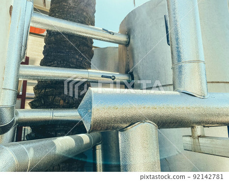 metal equipment. water bottle holder made of durable gray metal construction. metal frame. near palm and trees metal equipment. water bottle holder made of durable gray metal construction. metal frame. near palm and trees 92142781