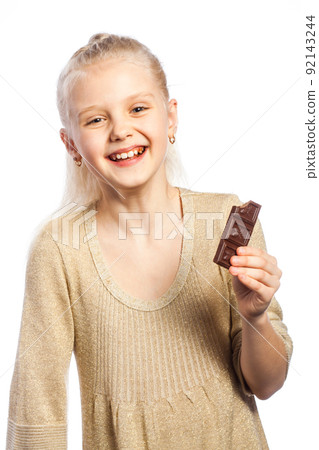 Beautiful girl biting chocolate. 92143244
