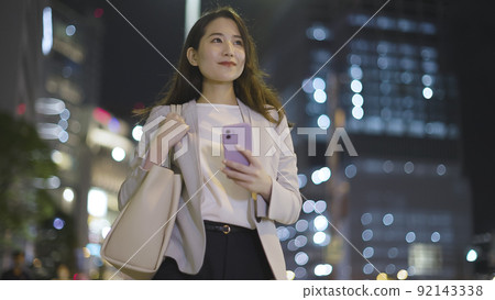 Business woman looking at a smartphone on the way home from work Female smartphone 92143338