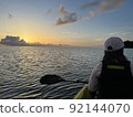 Woman watching the sunset with a sunset canoe 92144070
