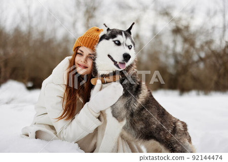 cheerful woman outdoors in a field in winter walking with a dog winter holidays 92144474
