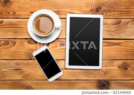 digital tablet and coffee cup on wooden table digital tablet and coffee cup on wooden table 92144940