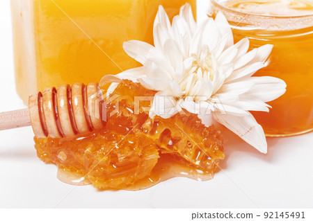 jar of honey and stick isolated on white background 92145491